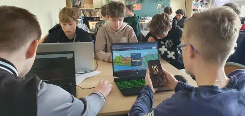 Uczniowie szkół podstawowych przy laptopach